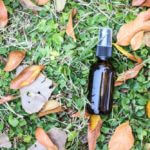 oil spray bottle on bed of clovers with leaves